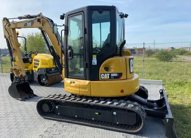 Détails techniques pour la Mini-pelle CATERPILLAR 305E Neuve : Poids opérationnel : 5 tonnes. Moteur : Caterpillar C2.4 Turbo, 40 kW (54 ch). Profondeur de creusage max. : 3,8 à 4 m. Largeur : 1,98 m. Hauteur : 2,54 m. Caractéristiques : Cabine spacieuse, rotation compacte, lame de remblayage.